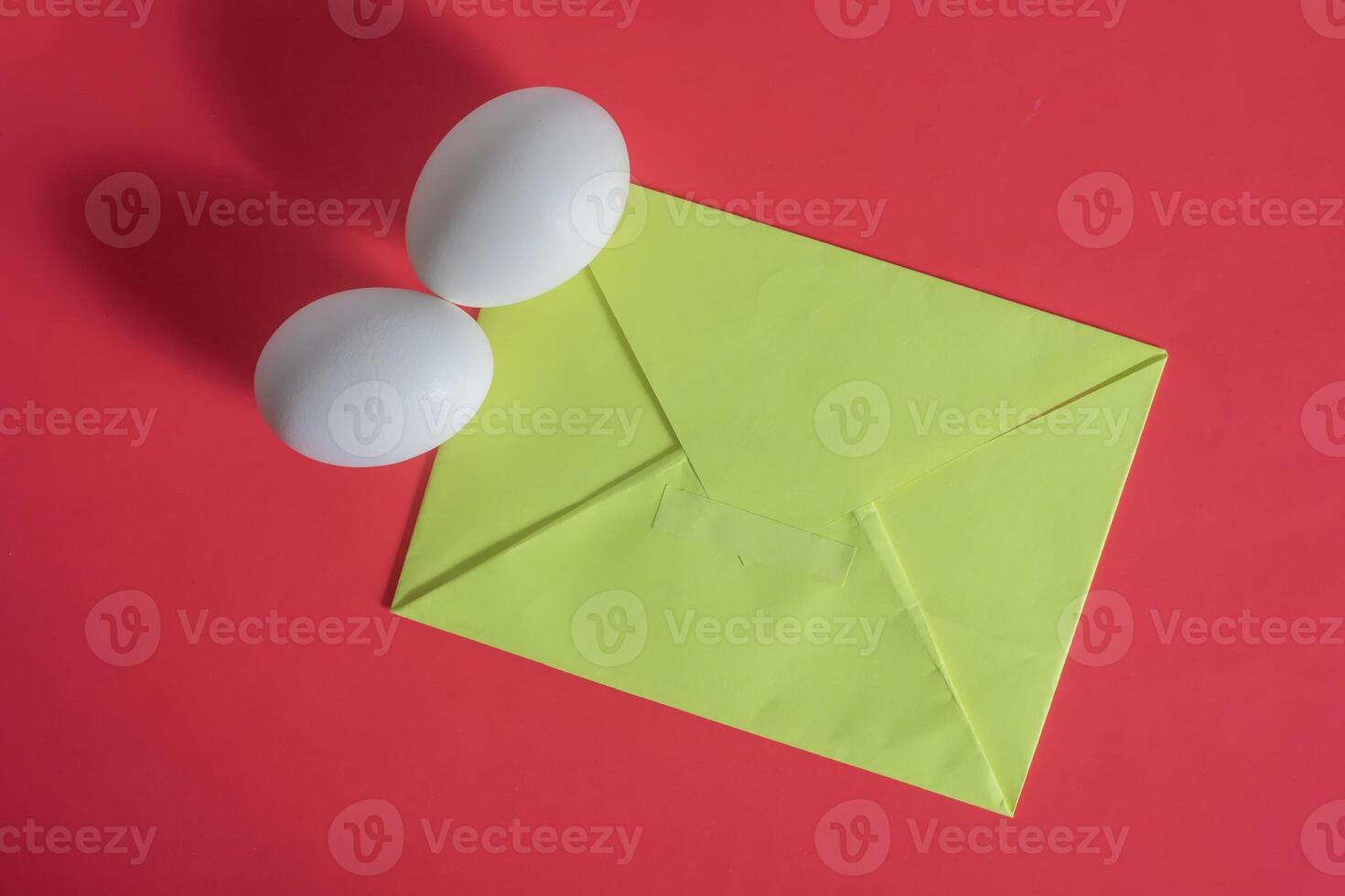 An envelope with two eggs on a red background photo