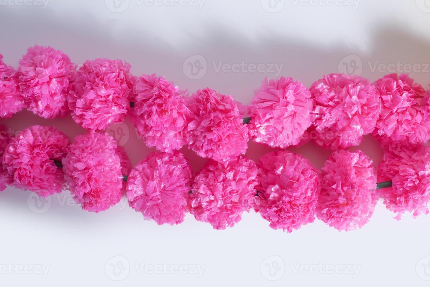 Beautifully decorated bright pink decorative artificial flower garland on a white background. photo