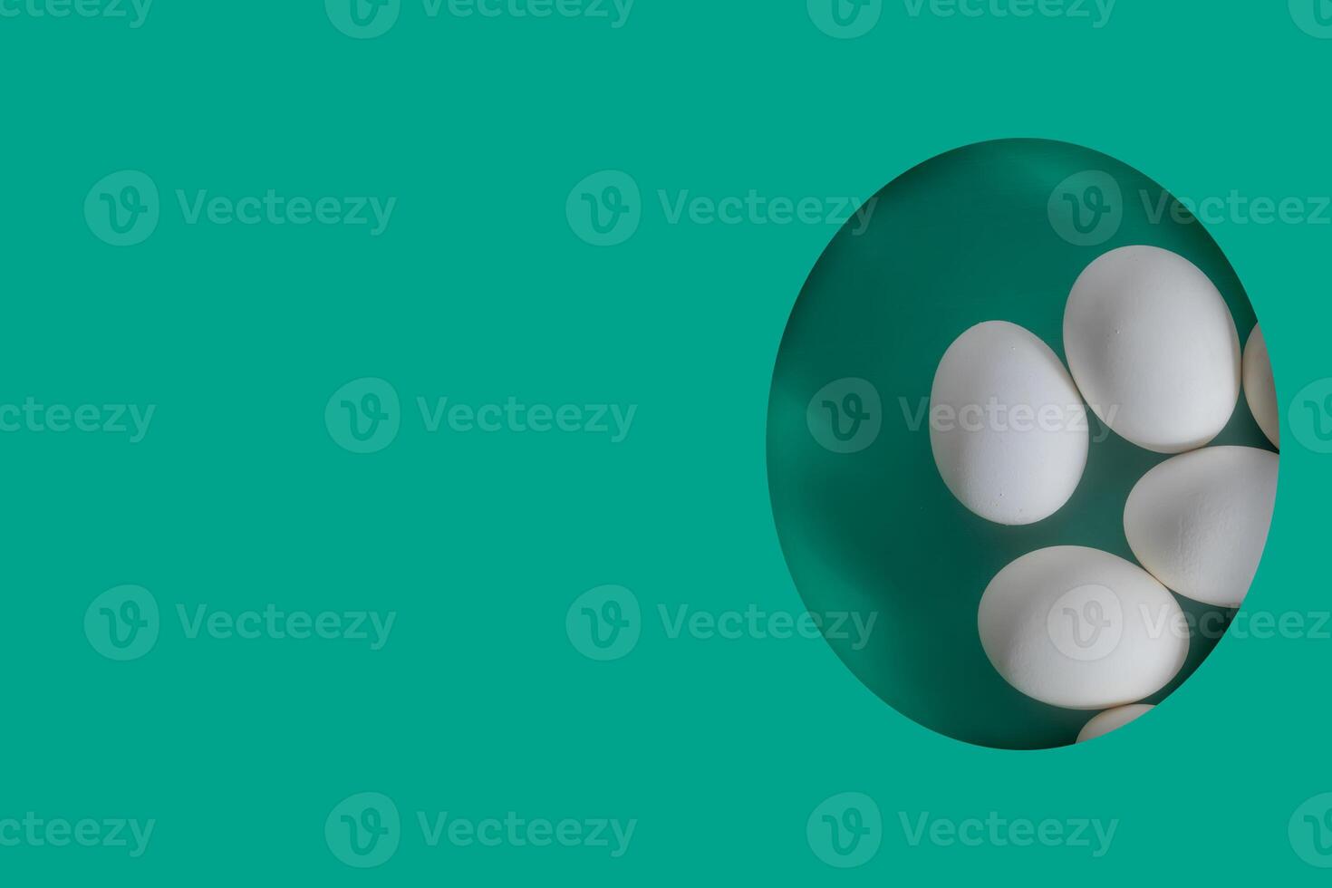 White eggs arranged on a green background in a creative oval frame, Paper cut egg, greeting card. photo