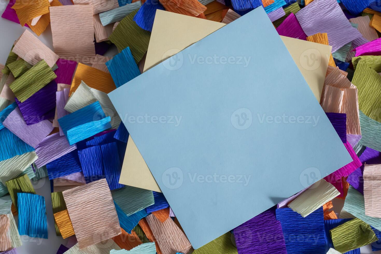 A piece of paper with a piece of paper on top of a pile of colorful paper photo