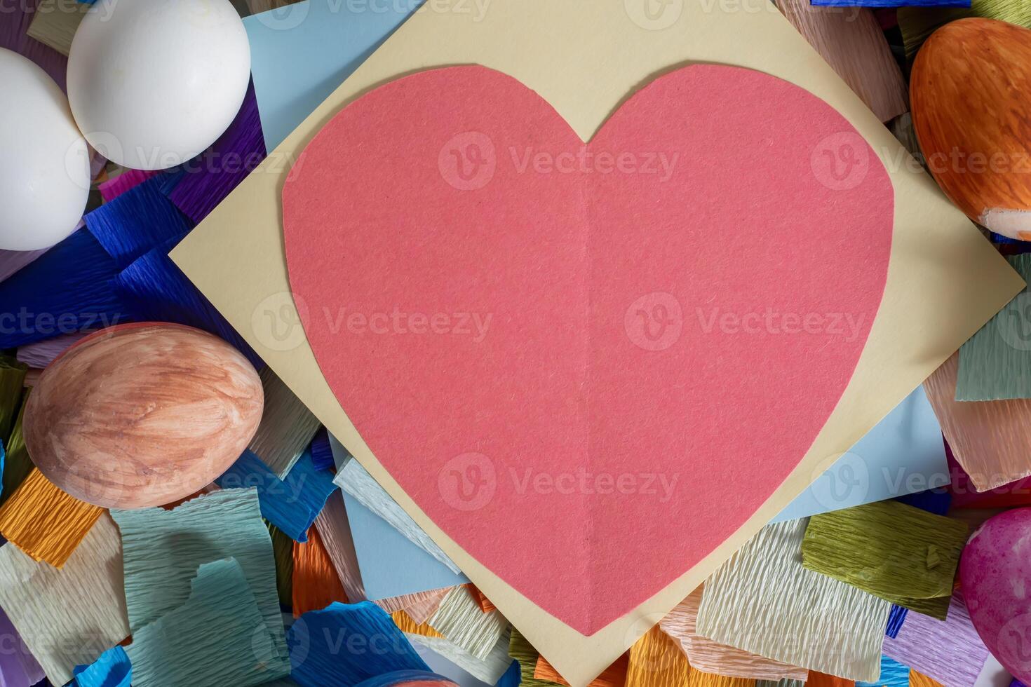 A heart shaped paper is surrounded by colorful eggs photo