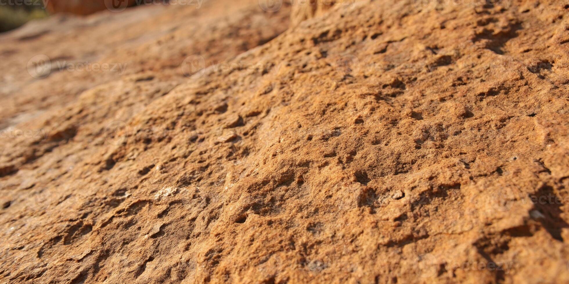 A close up of a rough sandstone surface, revealing tiny grains and warm earthy tones in stunning photo