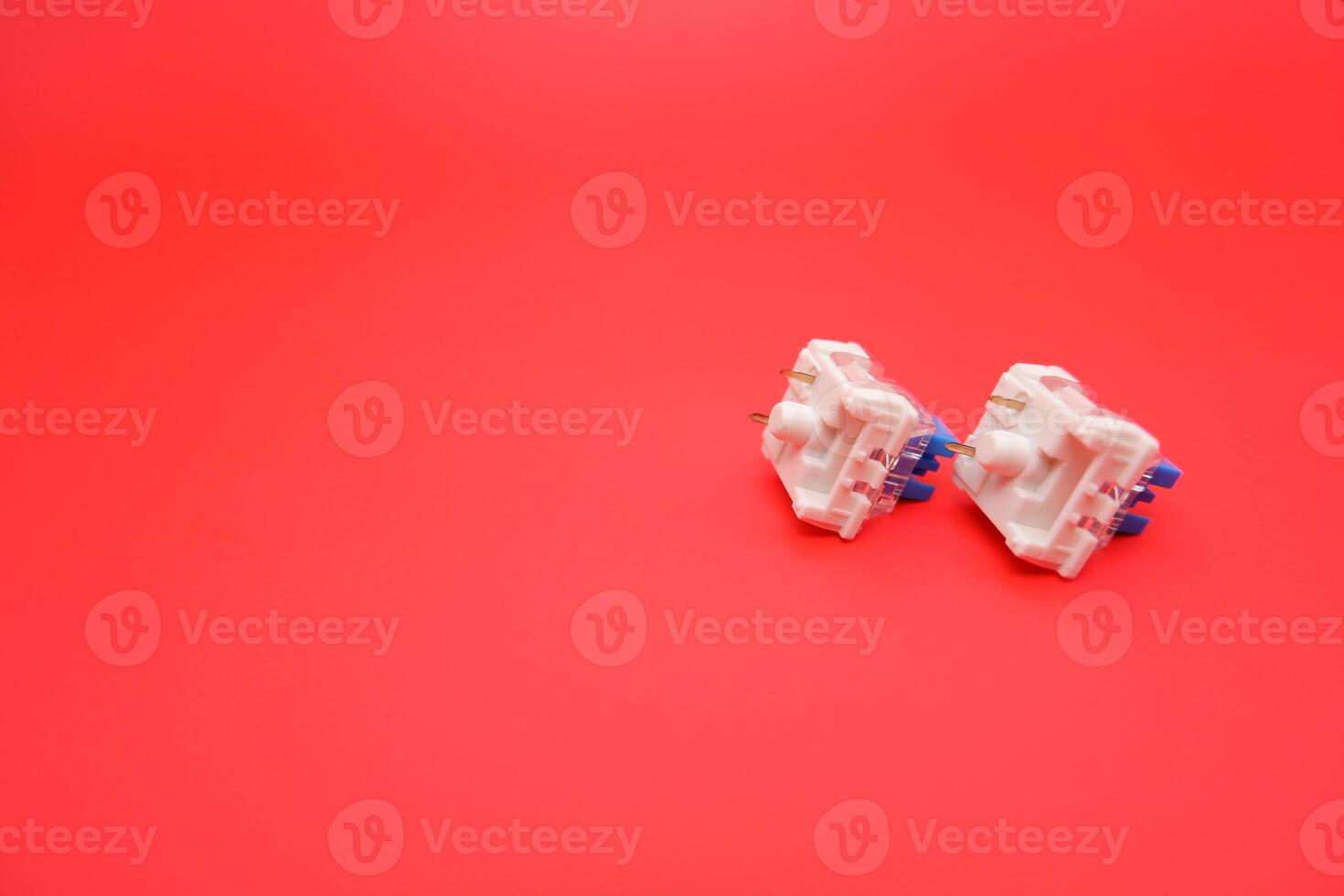 Close-Up of Blue Switch for Mechanical Keyboard on Red Backdrop photo