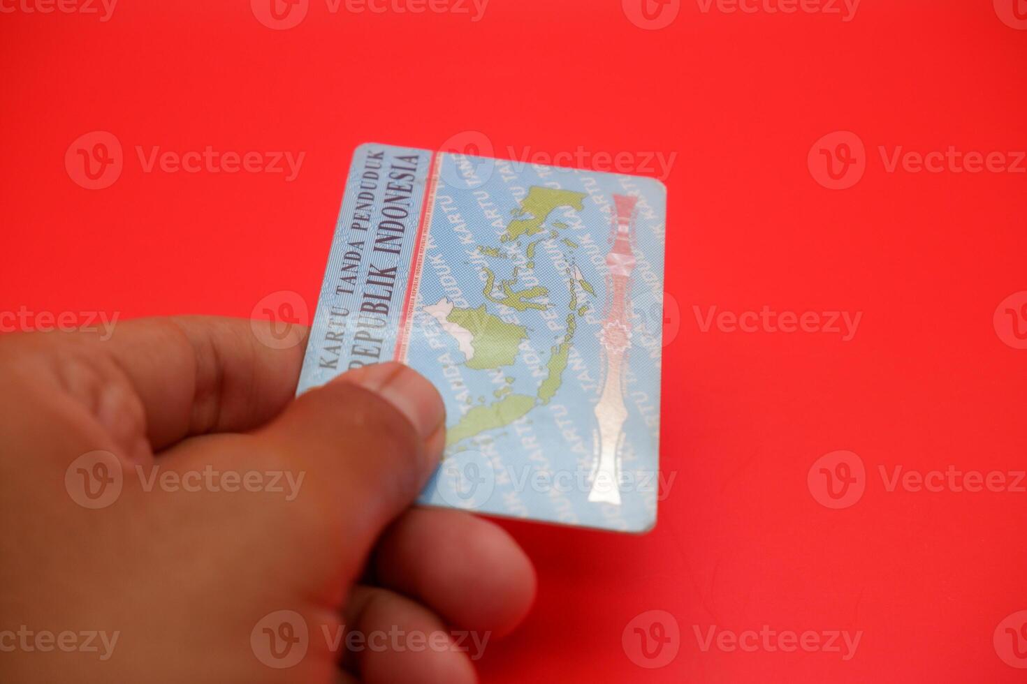 A detailed view of the Indonesian identity card resting on a red surface. The backside of the card is displayed clearly. photo