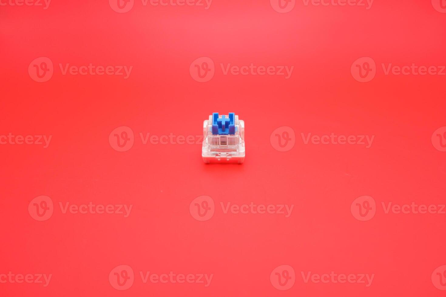 Tactile Blue Keyboard Switch Isolated with Red Backdrop photo
