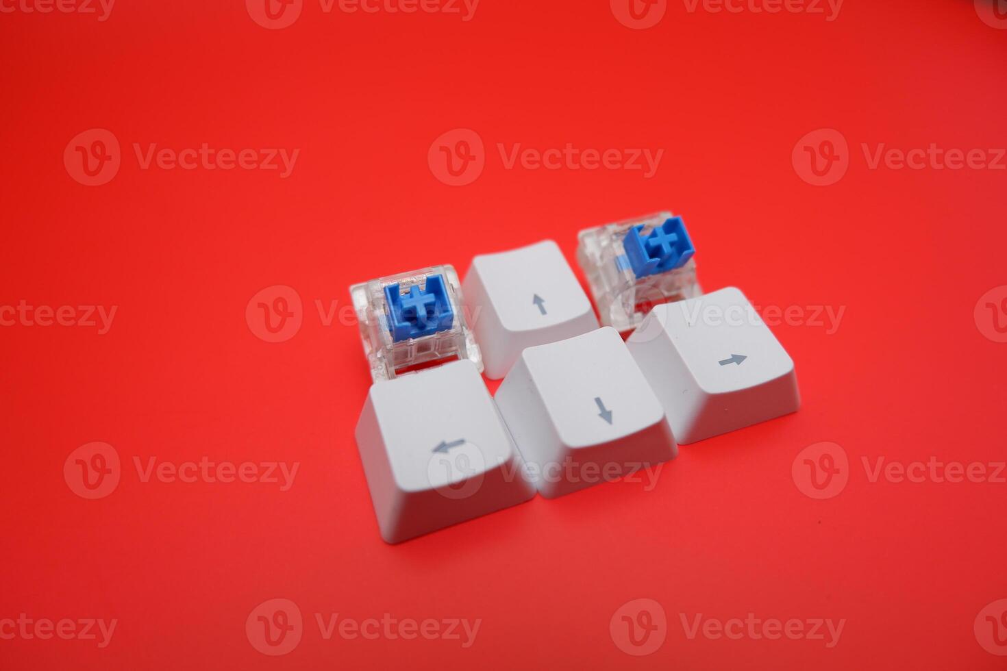 Blue Keyboard Switch and Keycaps Composition Against Red Backdrop photo