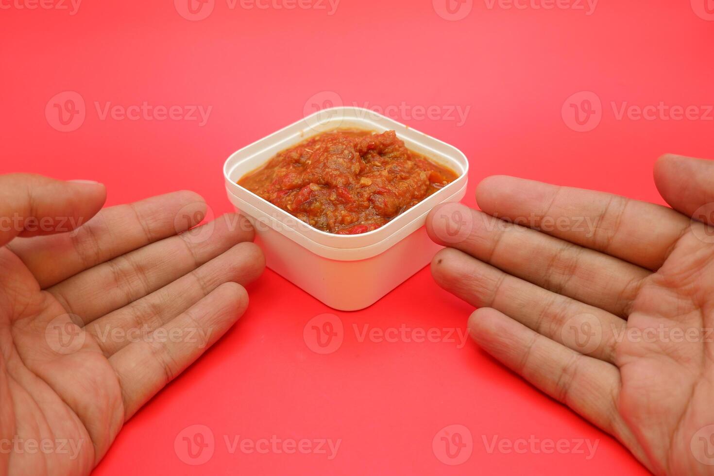 Spicy Lamongan Sambal in a Square White Bowl with a Bold Red Background photo