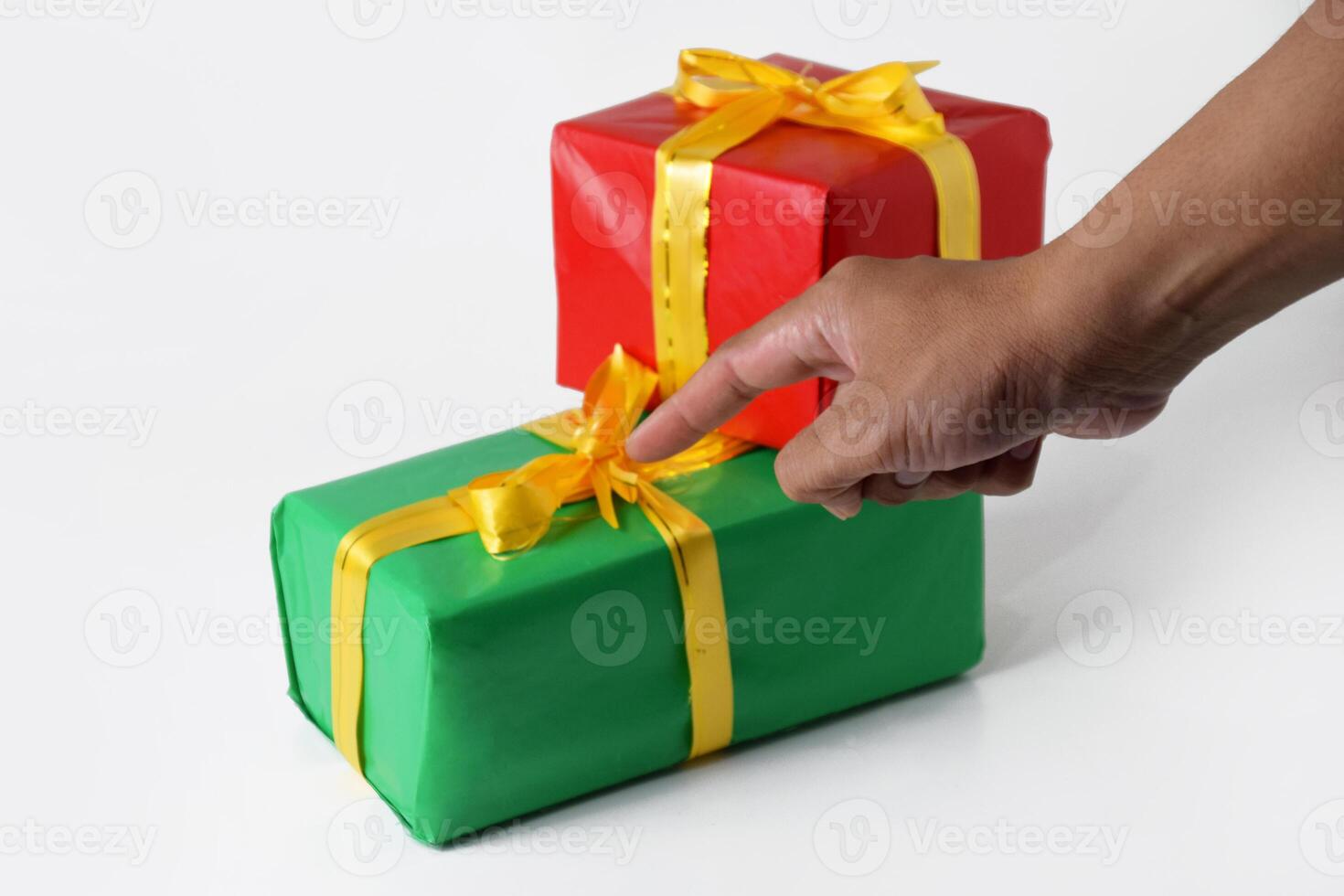 A Hand Gestures Toward Multiple Red and Green Gift Boxes with Golden Ribbons photo
