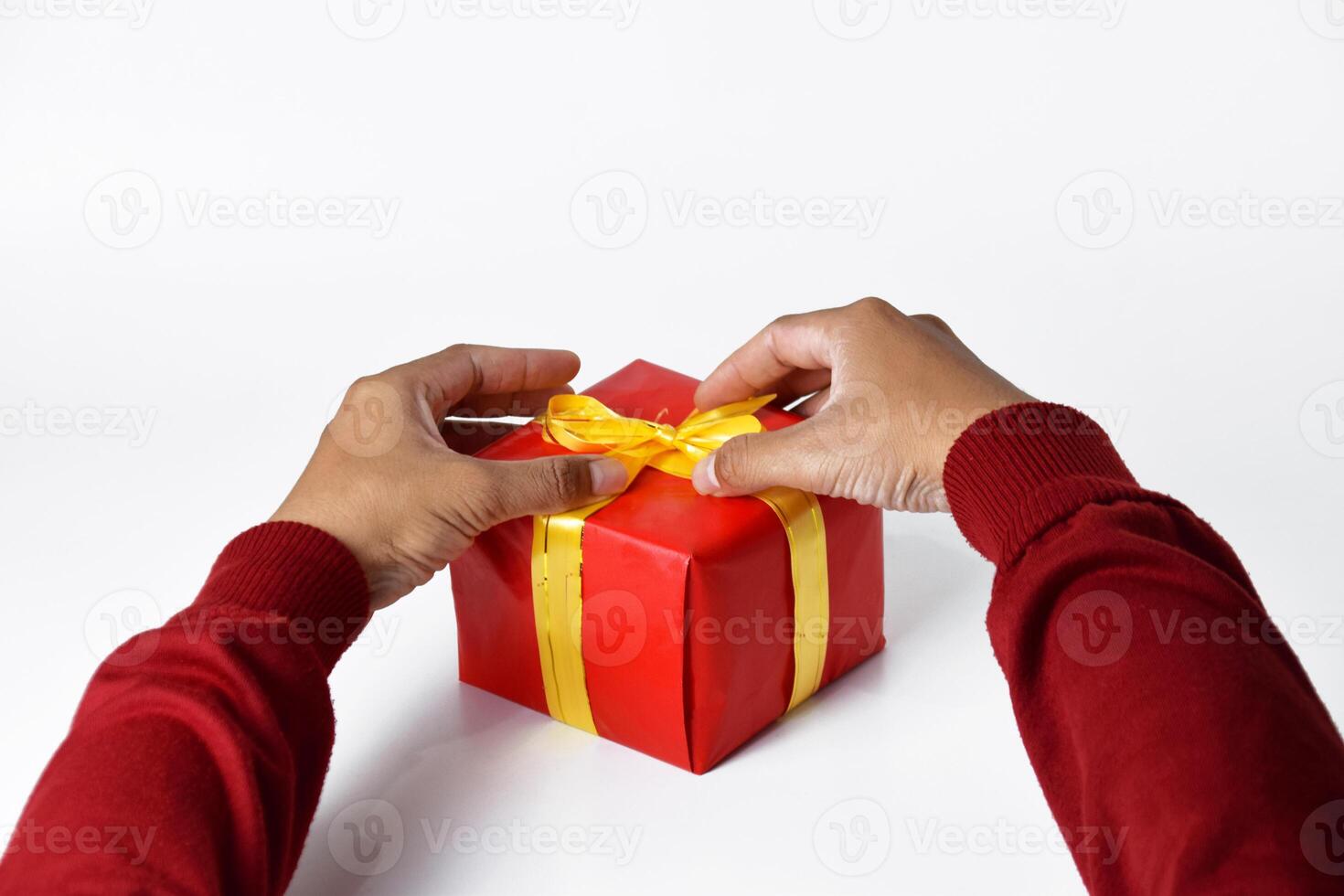 A Mans Hand in a Red Sweater Holding a Red Gift Box photo