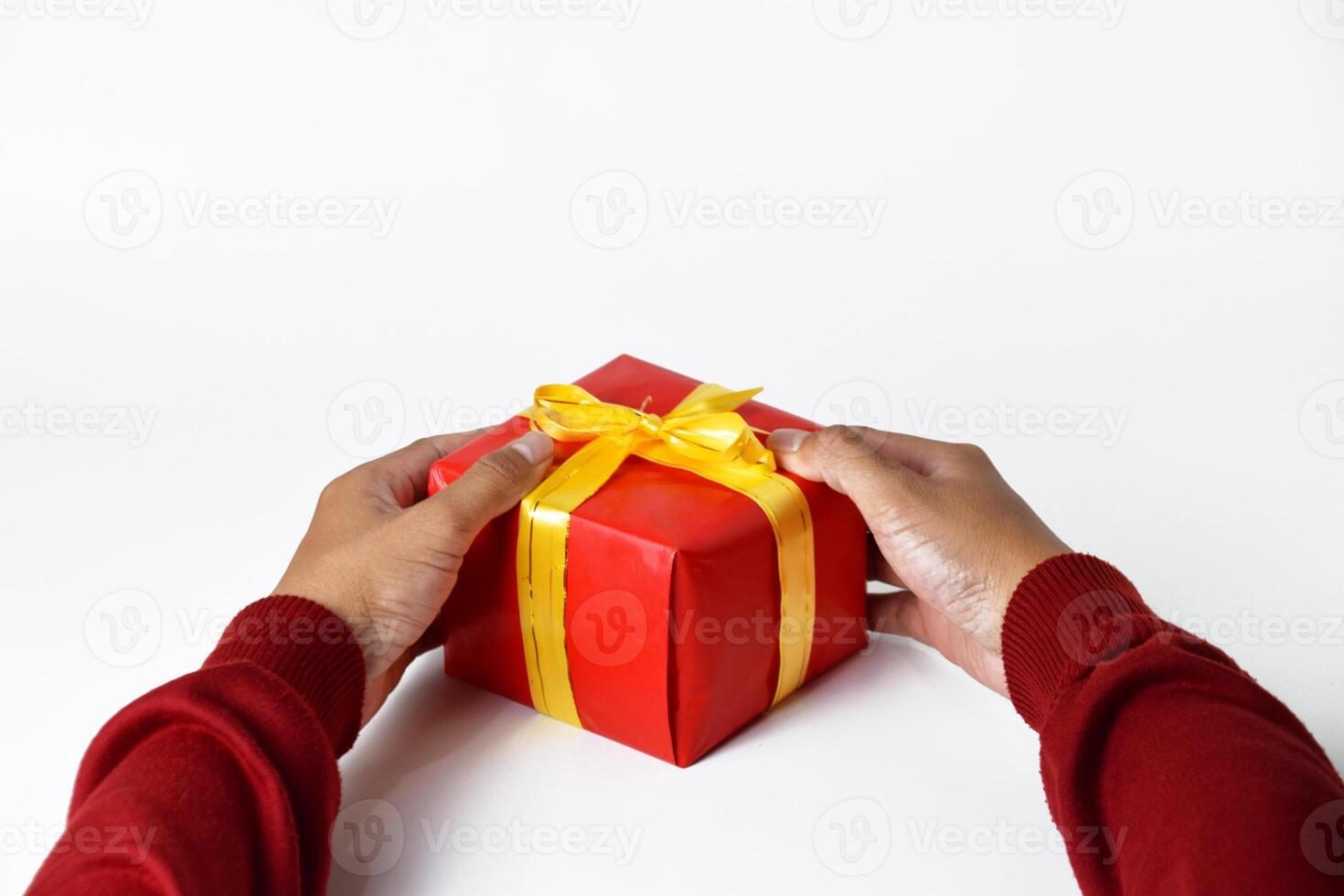 A Mans Hand Wrapped in Red Sweater Holds a Red Gift photo