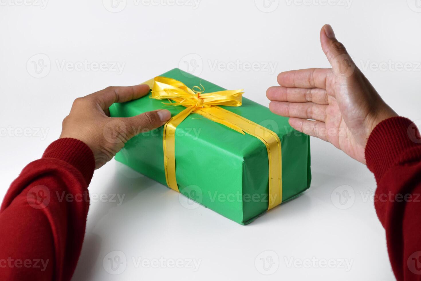 Festive Hands in Red Sweater Holding a Green Gift Box photo
