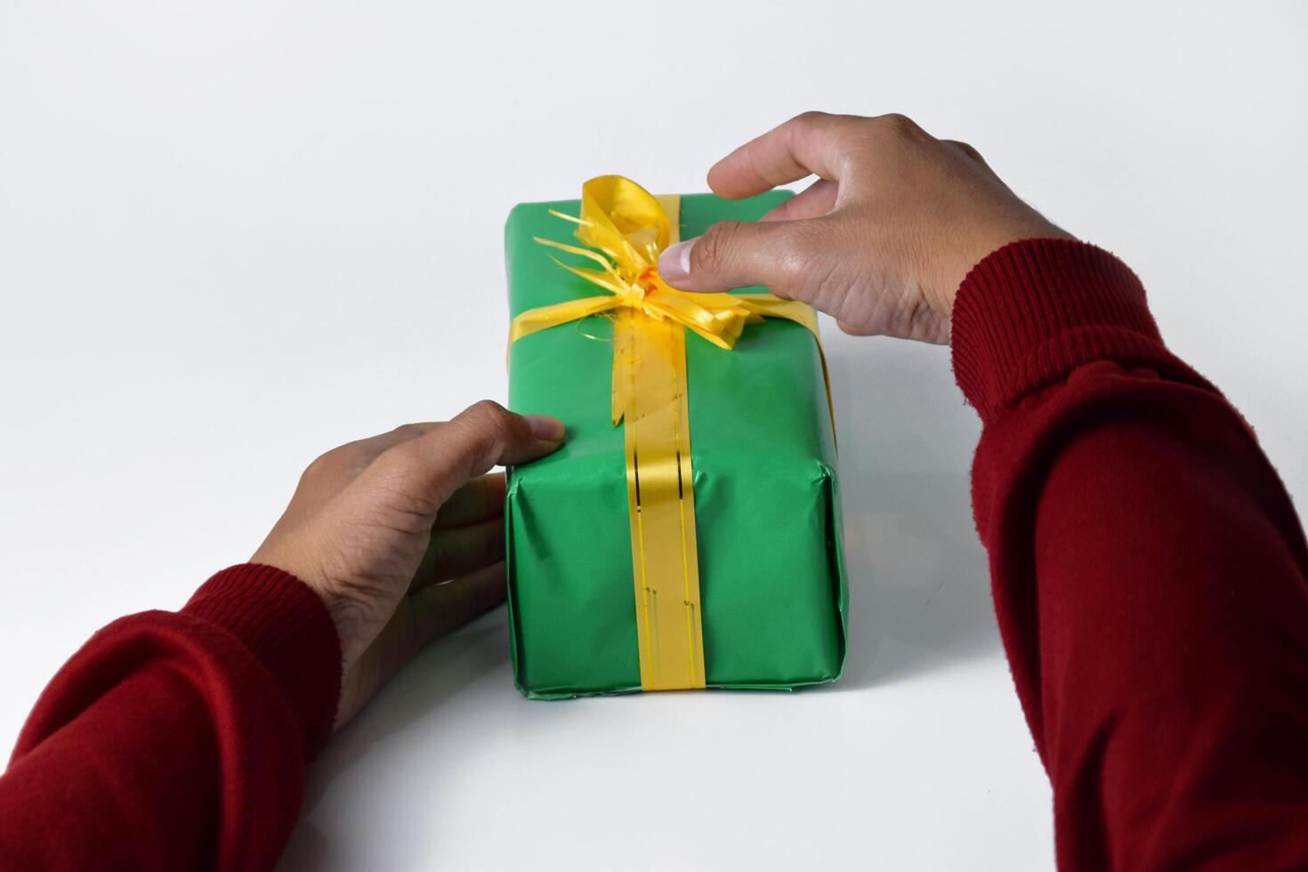 Hands Opening a Yellow-Ribboned Green Present photo