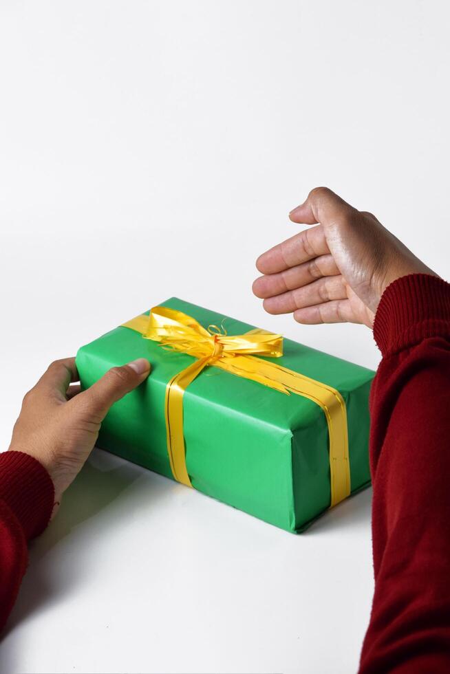 Hands in a red sweater holding a green gift box on a white background photo
