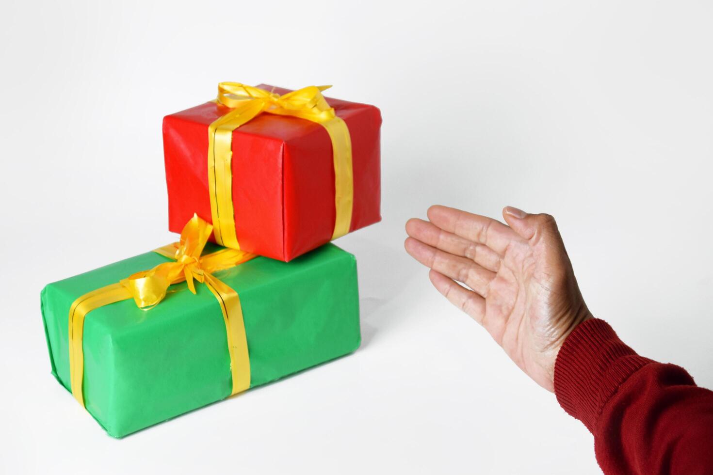 Hands of a person in a sweater holding a green and red gift photo