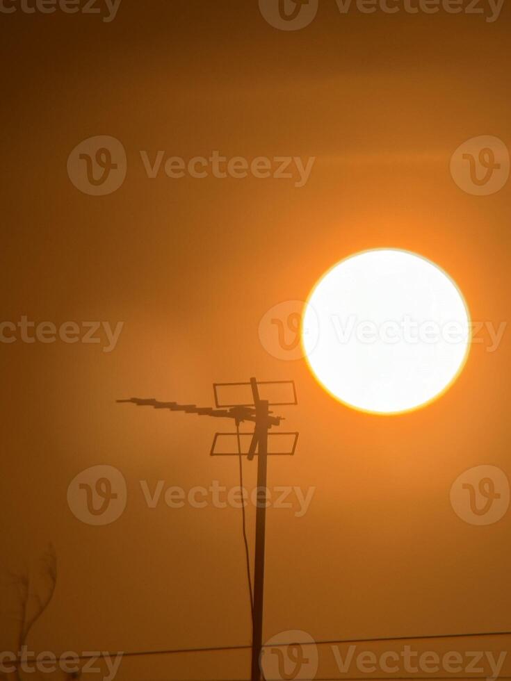Zoom Lens Striking Silhouette of TV Antenna with Glowing Sunrise and Nostalgic Vibe photo