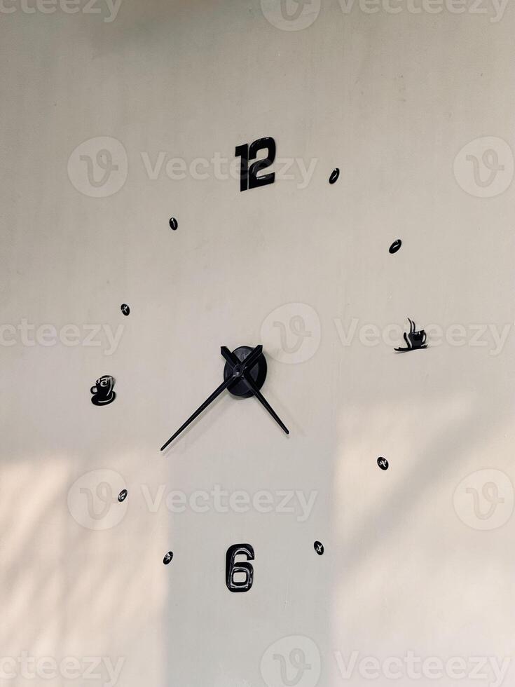 Minimalist Wall Clock with Black Numbers on White Wall photo