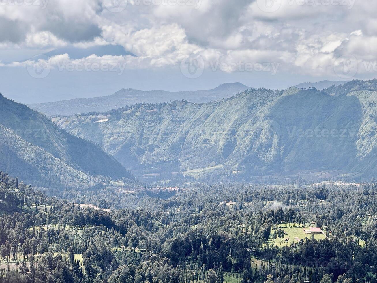 Lush Green Village and Mountain Landscape Under Cloudy Sky. Seruni Point Bromo photo