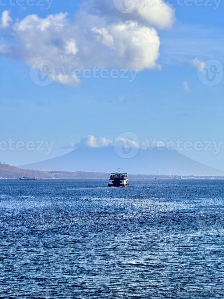 Ferry Boat on a Calm Sea with Distant Mountains photo