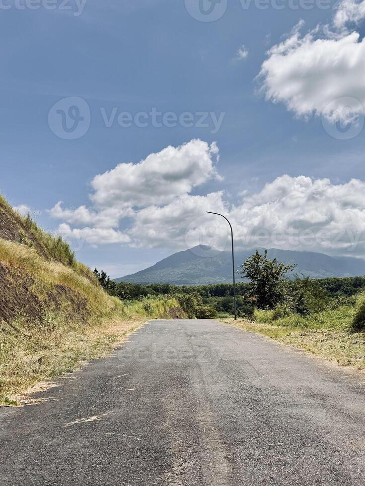 Asphalt Road Leading to Distant Mountain. Bajulmati Dam Situbondo photo