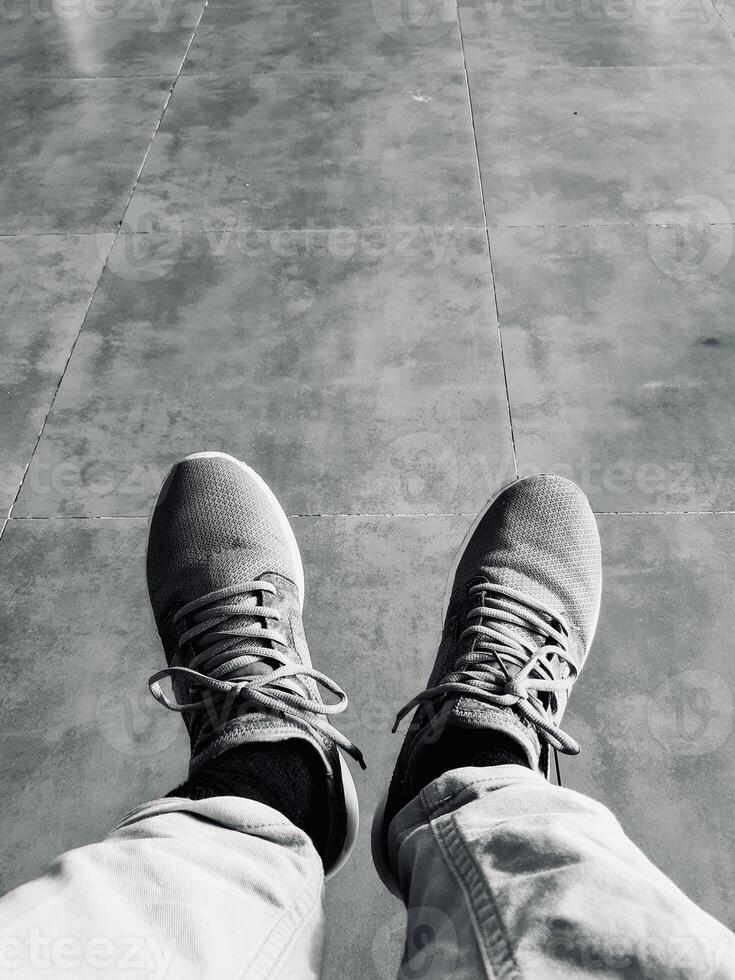 Monochrome View of Sneakers on Tiled Floor photo