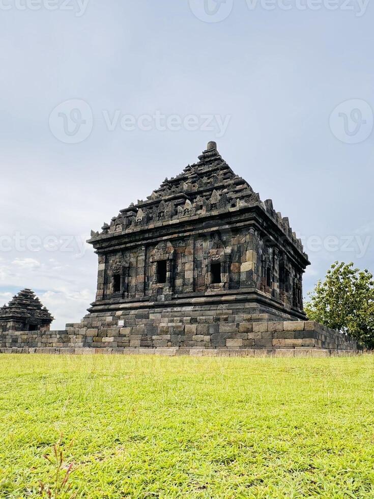 Ancient Stone Temple with Intricate Carvings and green grass. Candi Ijo Temple Yogyakarta photo