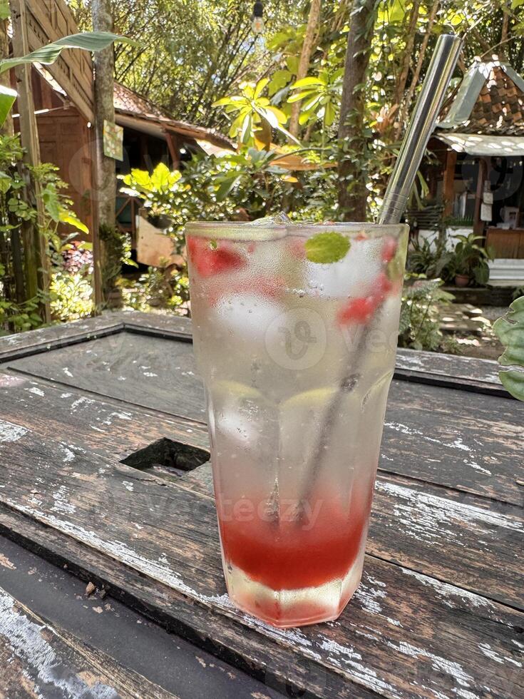Refreshing Iced Lemonade with Red Syrup in Garden Setting photo