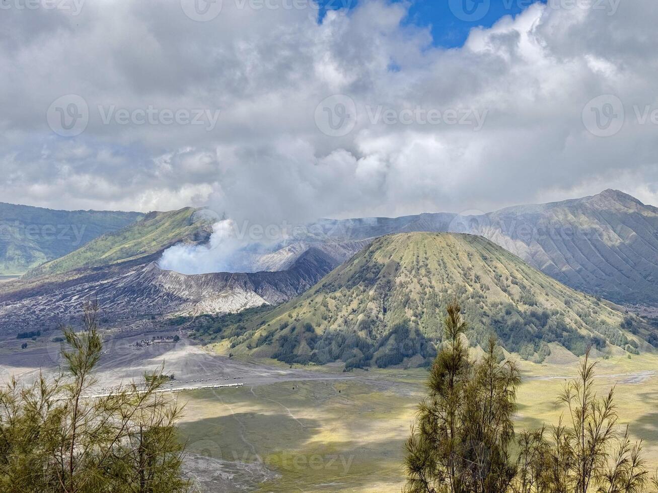 Mount Bromo with Smoke and Green Hills. Seruni Point Bromo photo