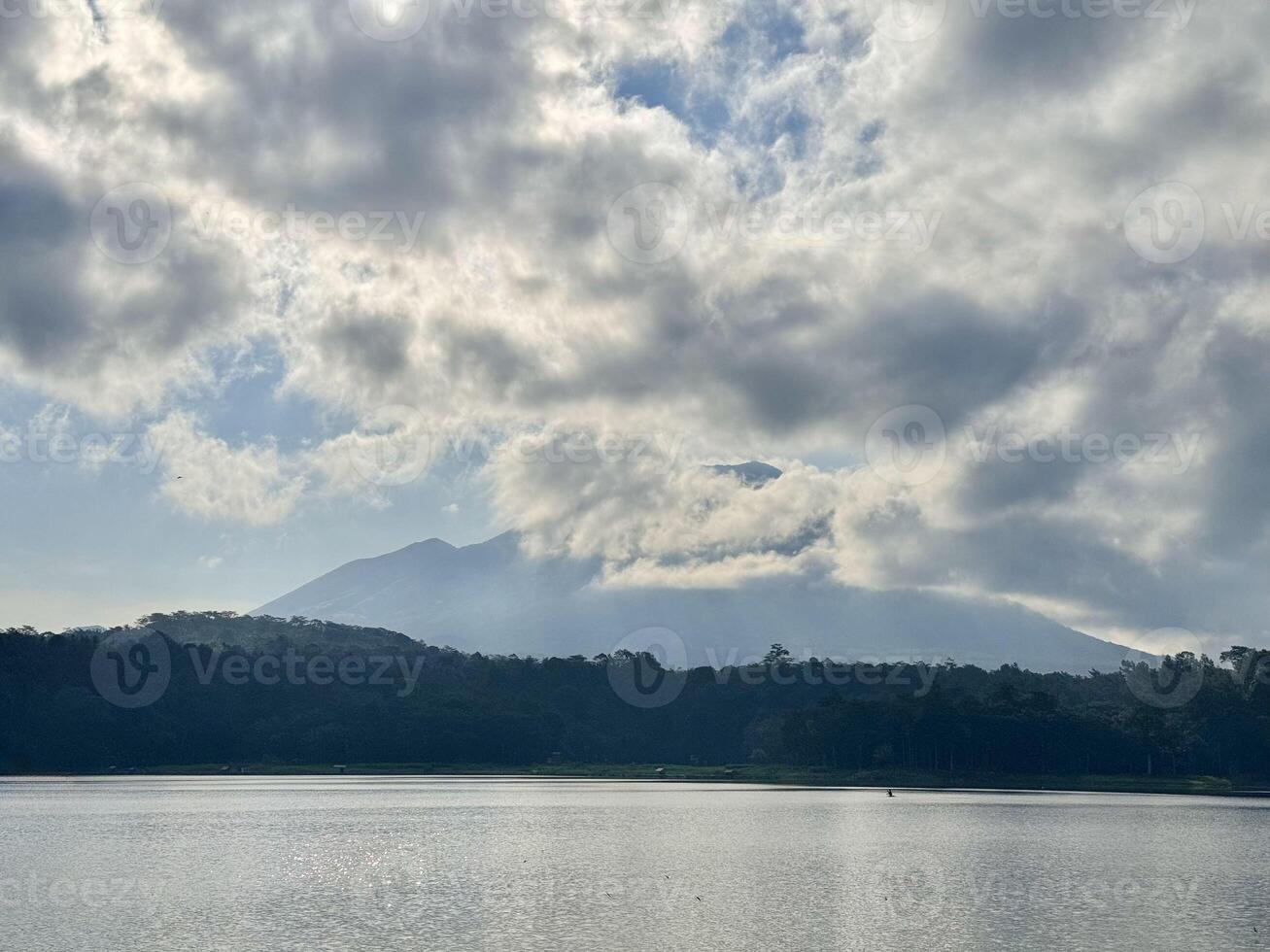 Serene Lake with Mountain and Clouds. Lemongan Mountain Lumajang, Indonesia photo