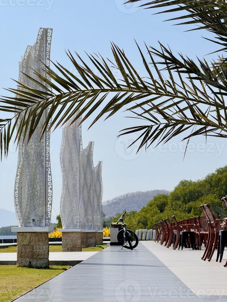Scenic Walkway with Sculptures and Palm Trees. Capture from Utama Raya Situbondo photo