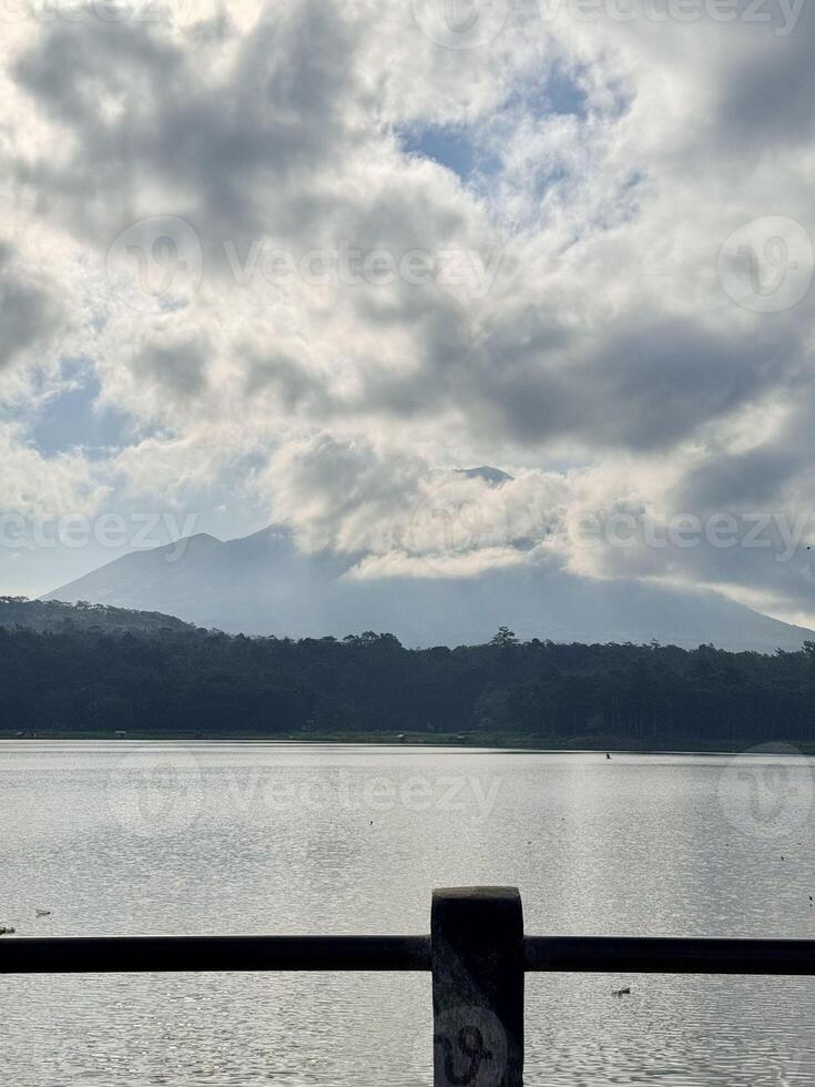 Scenic Lake and Mountain View with Dramatic Clouds. Lemongan Mountain Lumajang, Indonesia photo