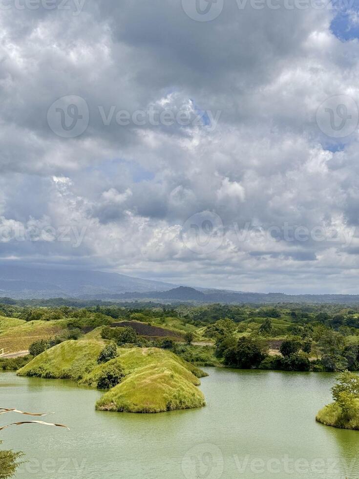 Scenic Lake with Green Islands and Cloudy Sky. Bajulmati Dam Situbondo photo