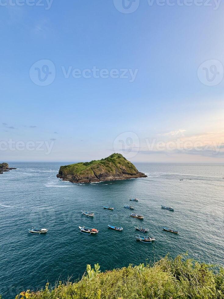 Island and Boats in Tranquil Ocean View. Payangan Beach Jember, Indonesia photo