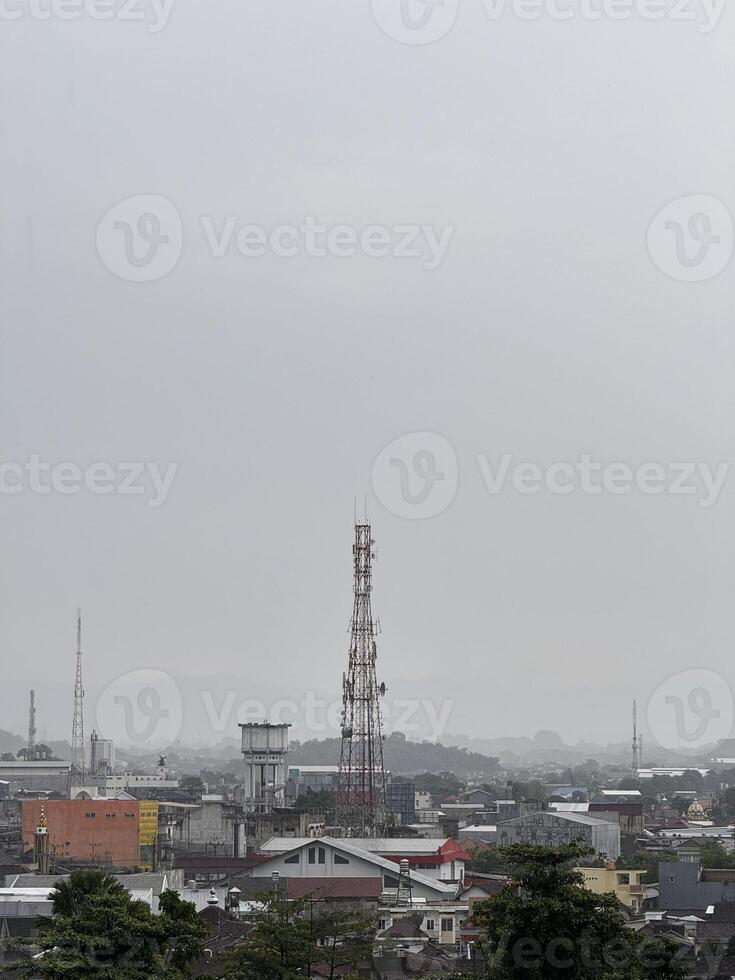 Cityscape with Telecommunication Towers and Cloudy Sky photo