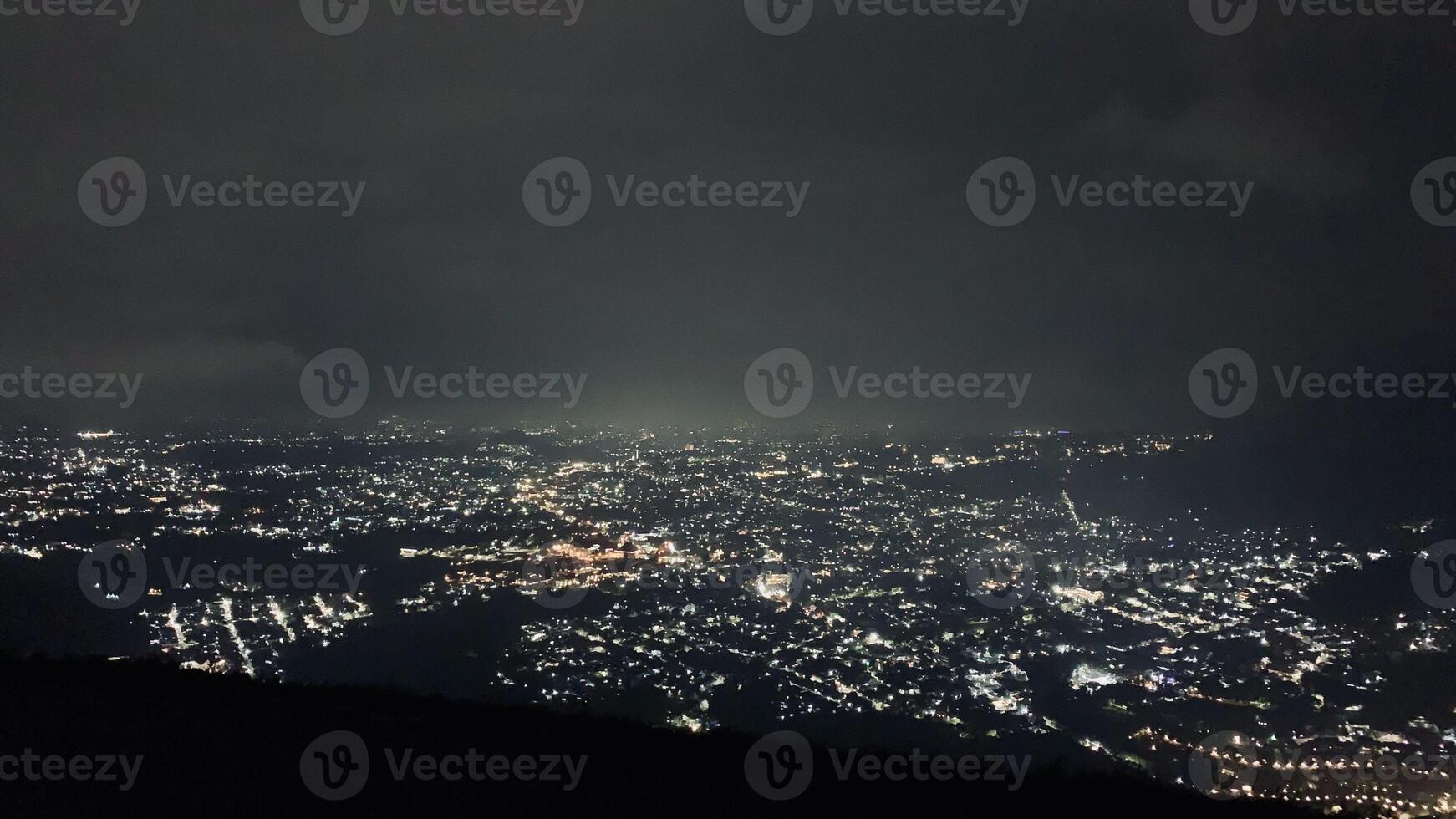 Nighttime Cityscape with Illuminated Lights. Paralayang Batu Malang, Indonesia photo