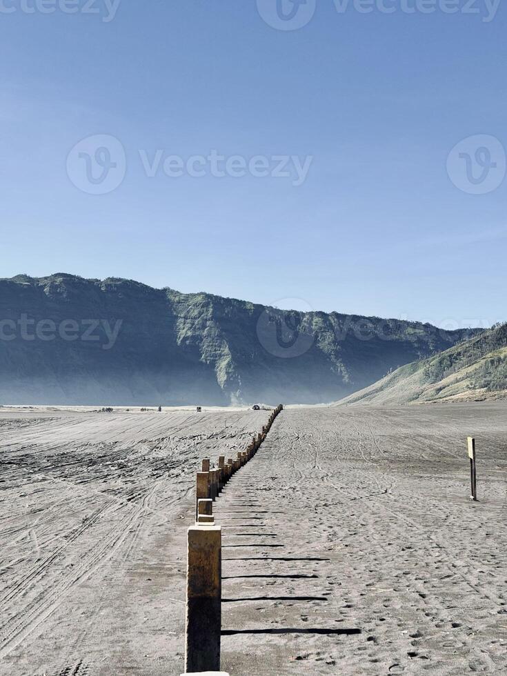Barren Landscape with Wooden Posts and Distant Hills. Pasir berbisik Bromo National Park. photo