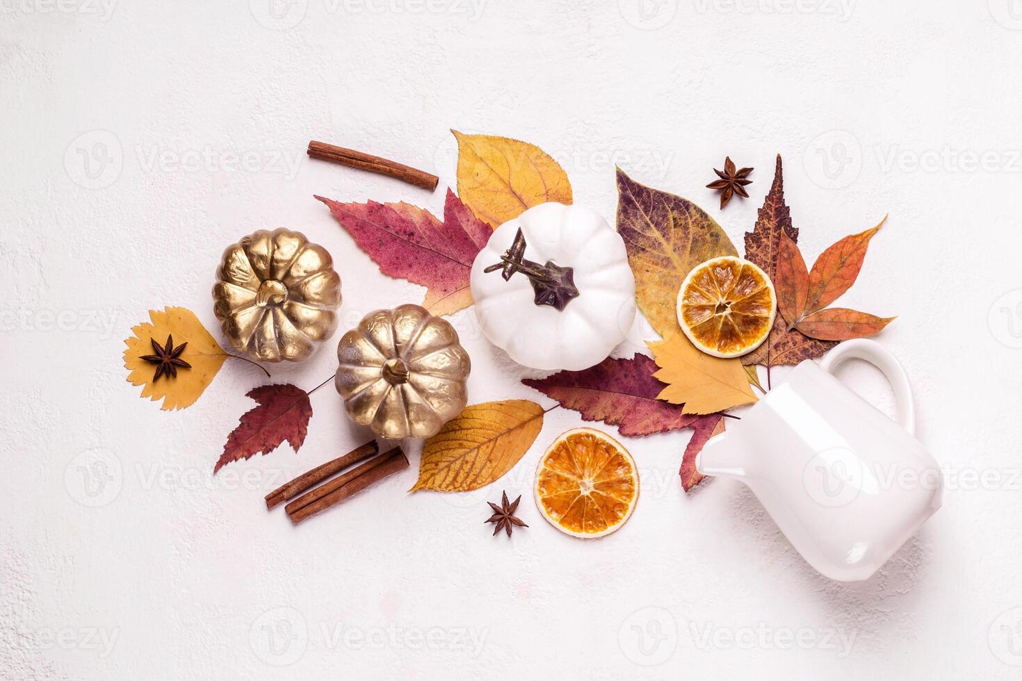 Creative layout made of golden pumpkins and leaves. Autumn floral composition photo