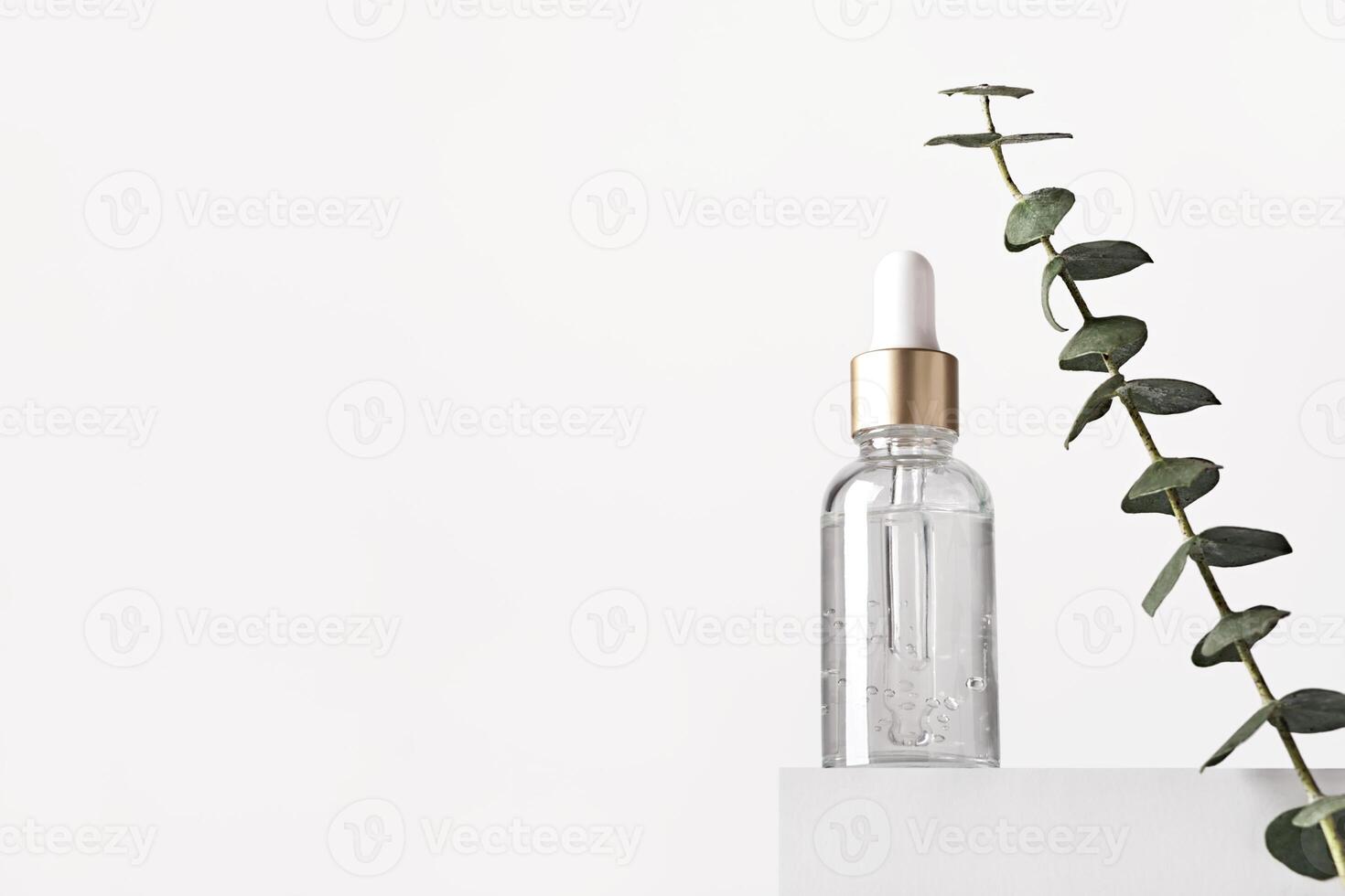 Natural skin care products concept. Herbal mineral cosmetics, serum, hyaluronic acid on white podium. Transparent dark glass bottle with dropper, copy space photo