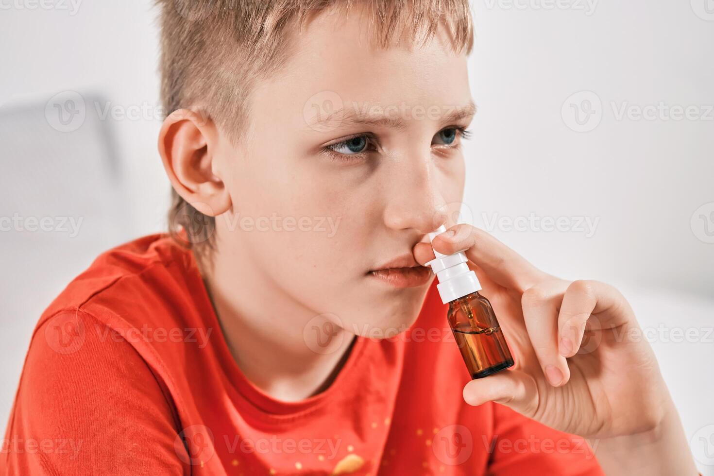 Blond Boy drips nose drops from runny nose. Treatment of colds and allergic rhinitis photo
