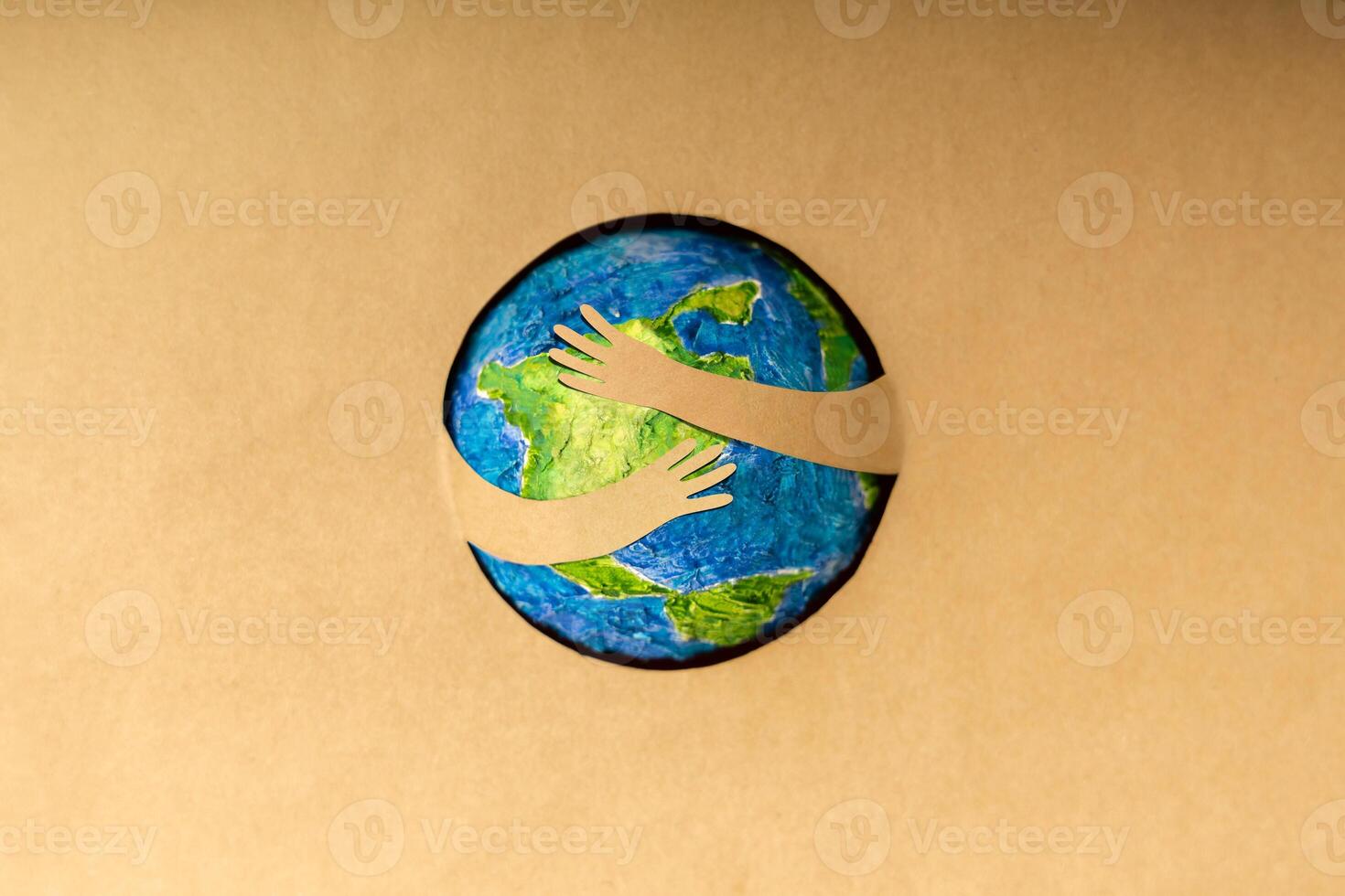 World Earth Day Concept. Green Energy, ESG, Renewable and Sustainable Resources. Environmental Care. Paper Cut as Arms Embracing Green Globe. Top View photo