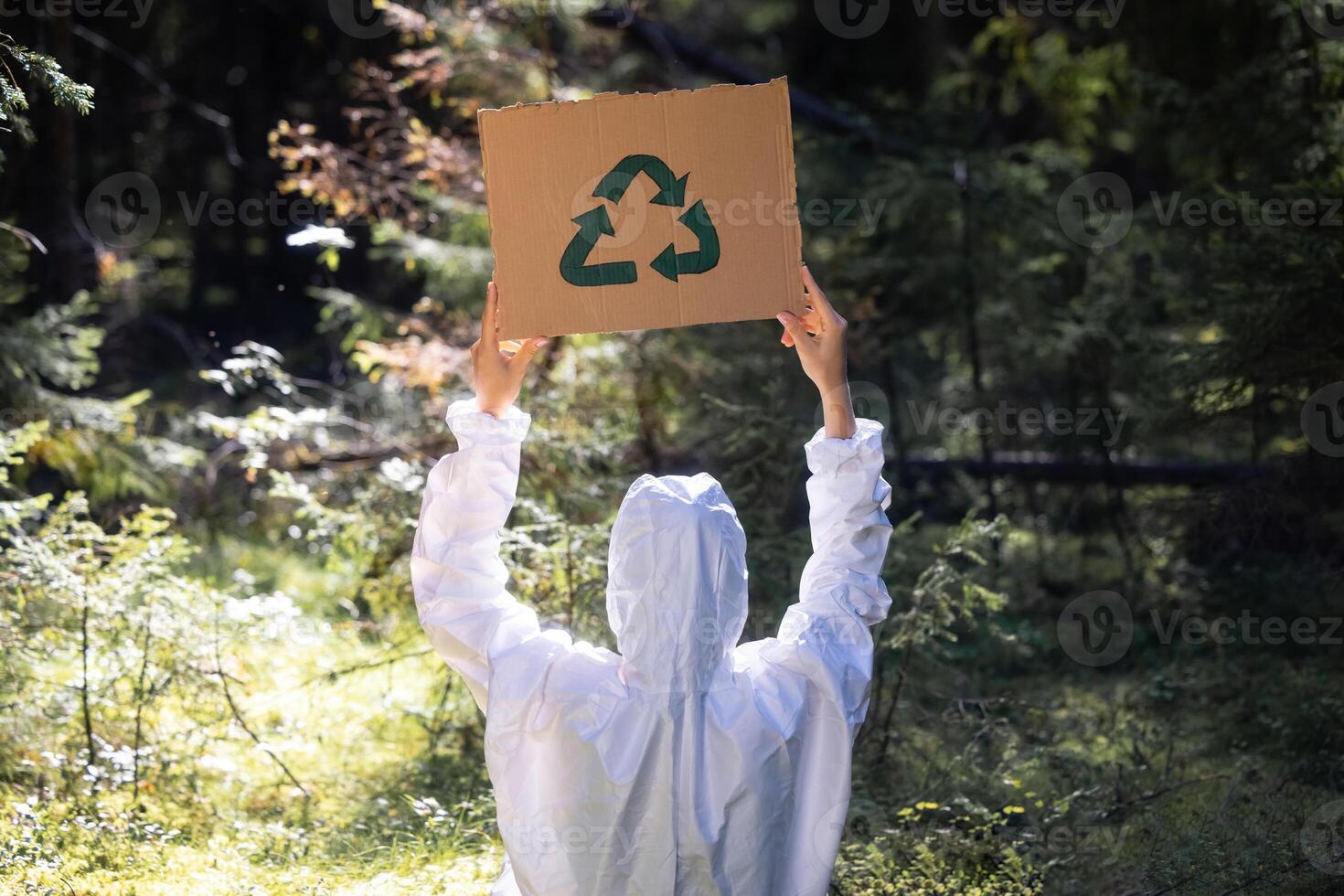 Doctor in a white anti-epidemic suit holding a cardboard banner in hands photo