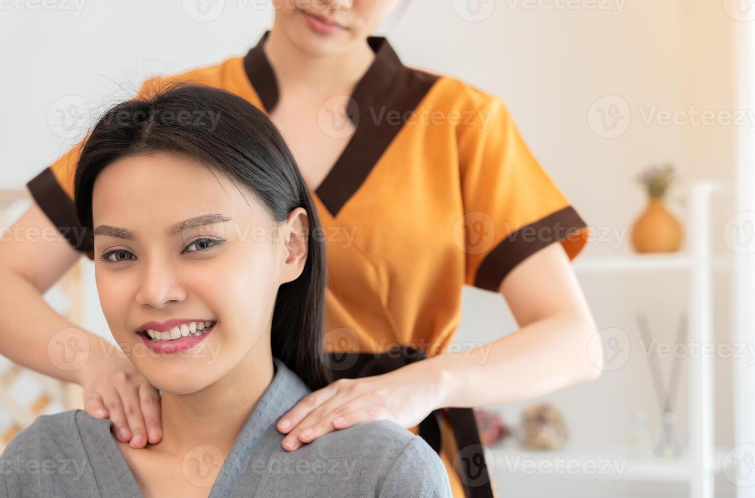 Smiling young woman getting neck massage photo
