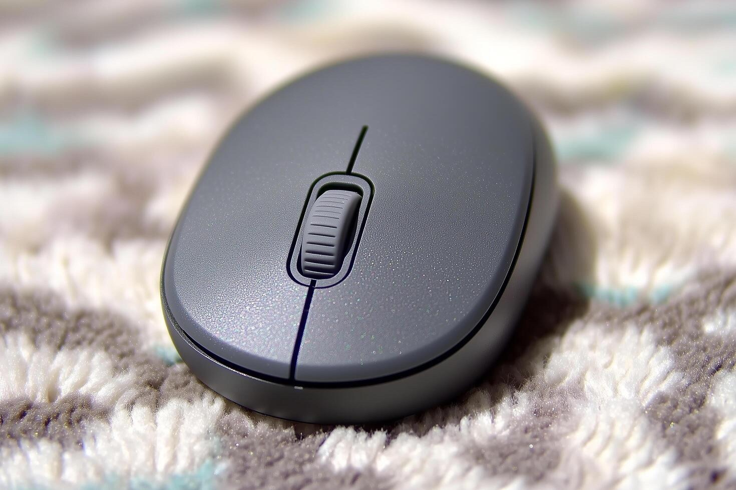 Close-Up View of a Gray Computer Mouse on a Textured Surface with Soft Colors and Patterns photo