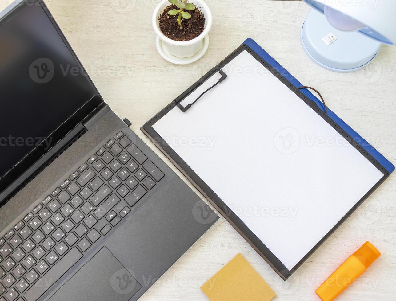 Picture of the plastic folder on the office desk with paper clip holder on the top and other office items. A4 size paper mock up. Stationary photo