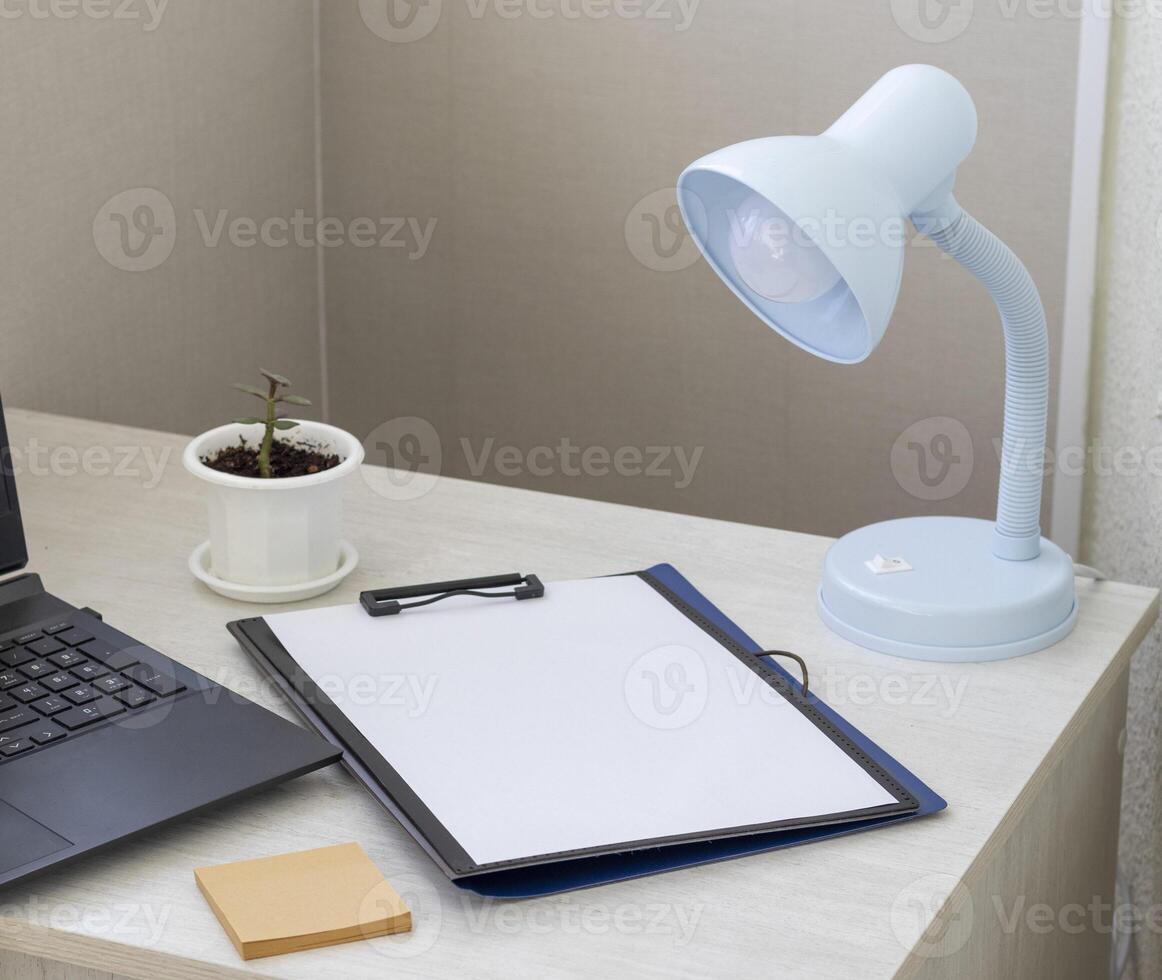 Shot of the plastic folder on the office desk with paper clip holder on the top and other office items. Stationary photo