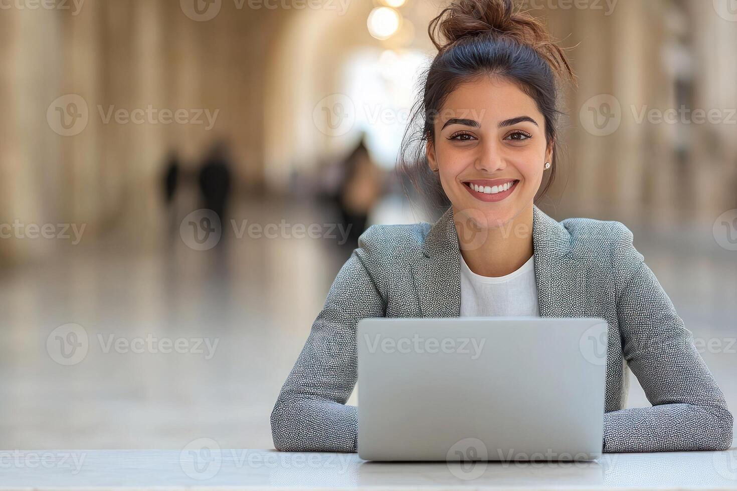 Young professional smiling while working on laptop in elegant indoor space photo
