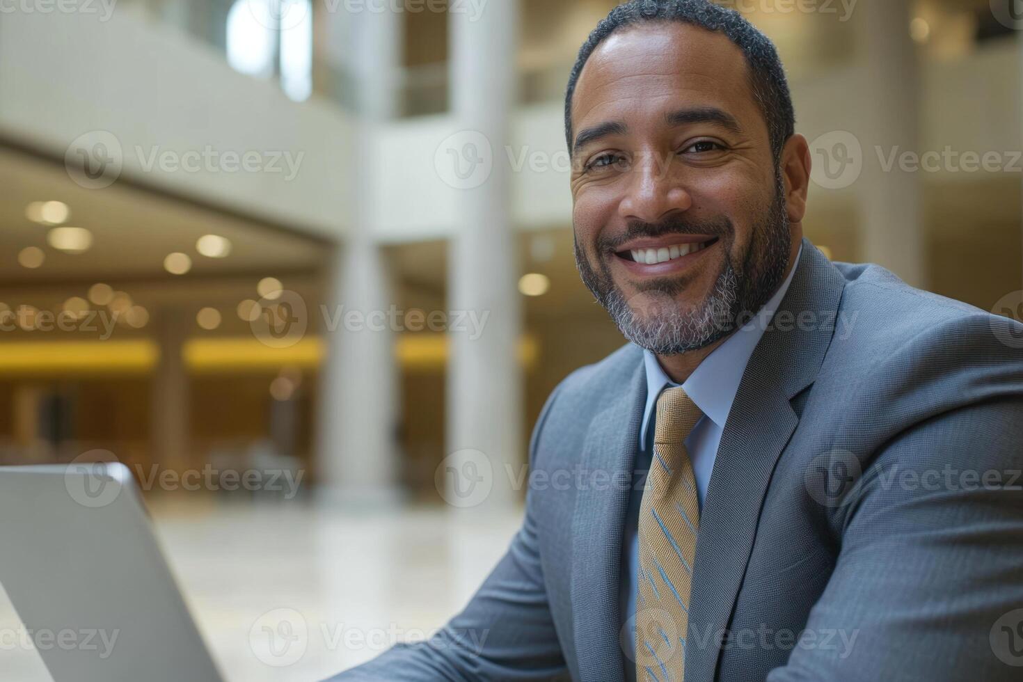 Business professional smiles confidently while working on laptop in modern office environment photo