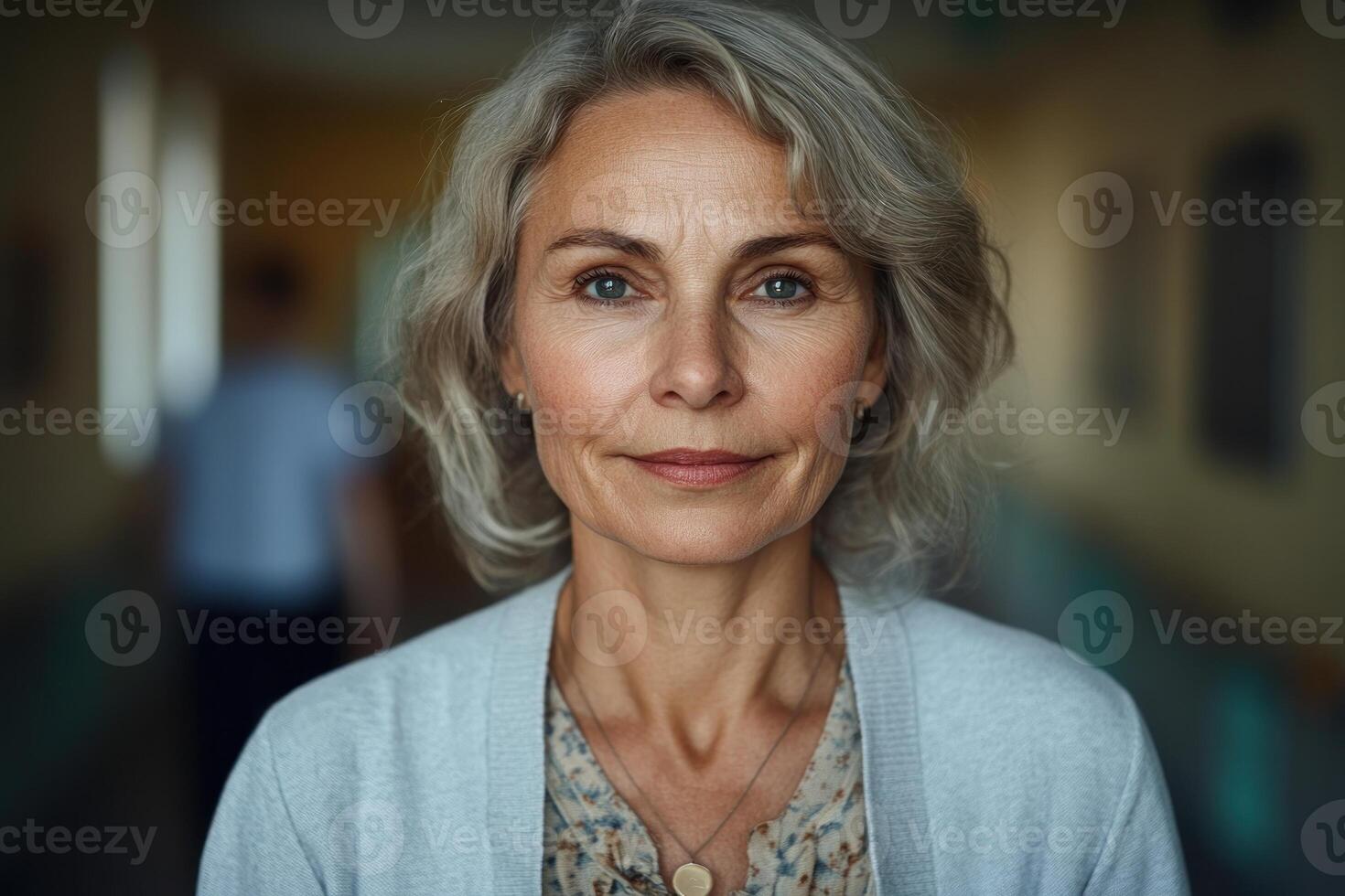 Mature woman with gray hair in a hallway, displaying calm expression during a candid moment photo