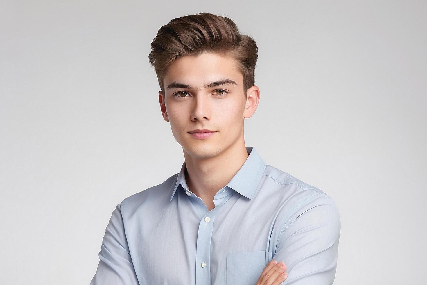 Young man in blue shirt standing with arms crossed photo