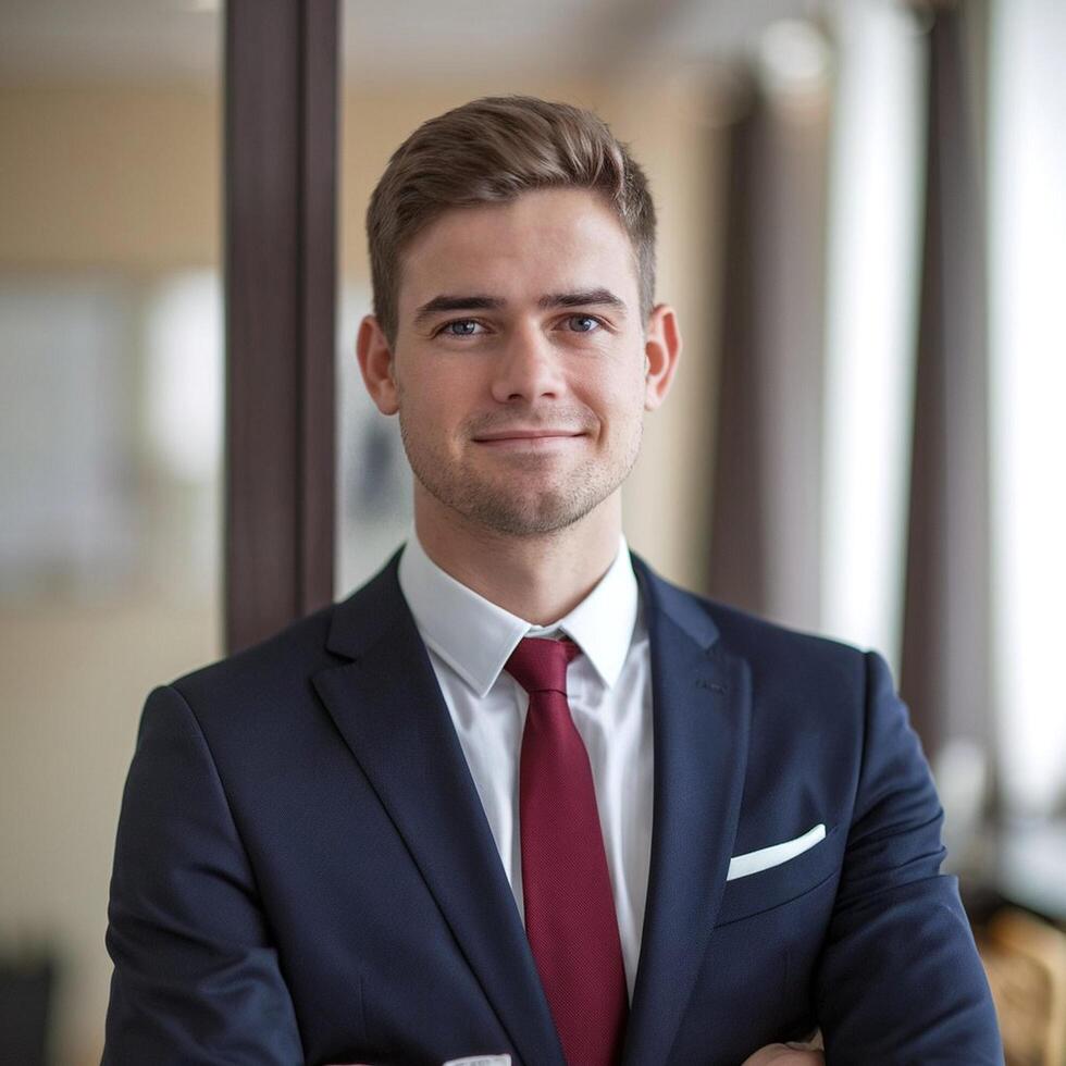 A young man in a suit and tie standing in front of a window photo