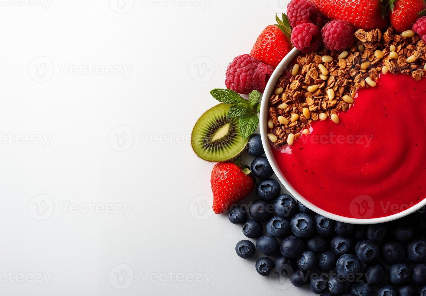 Colorful smoothie bowl with strawberries, blueberries, raspberries, and granola, garnished with kiwi and mint leaves, creating vibrant and healthy breakfast option photo